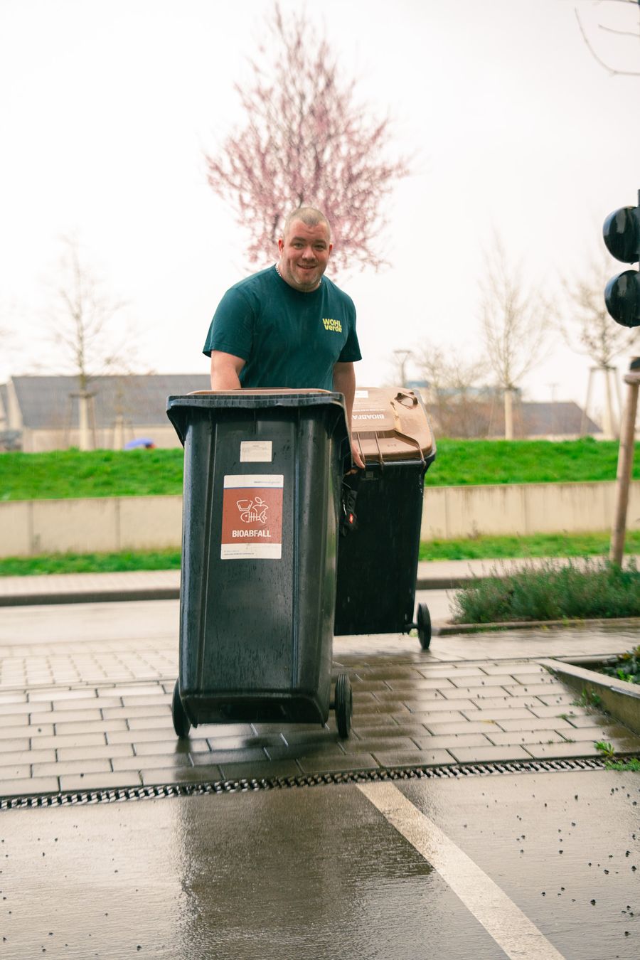 Mitarbeiter stellt Mülltonnen bereit