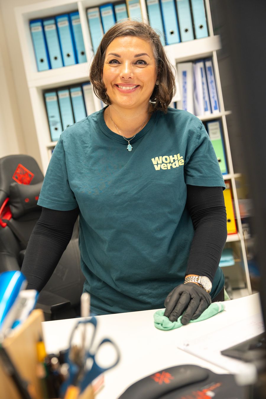 WOHLverde-Mitarbeiterin reinigt einen Schreibtisch